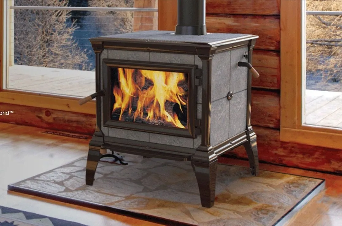Hearthstone soapstone wood stove burning in a living room with a picture window behind it