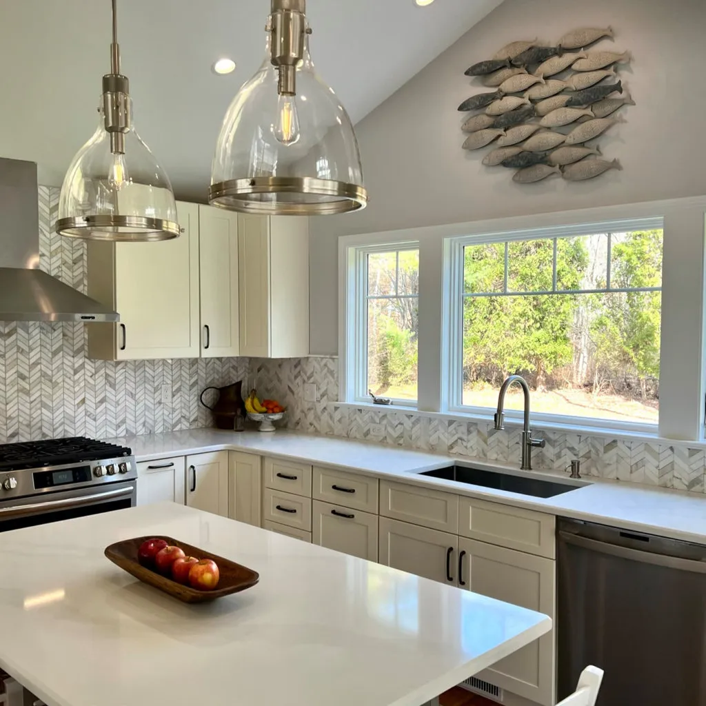 Beach-style kitchen with white shaker cabinets and quartz countertops designed by Pondside in Madison, CT
